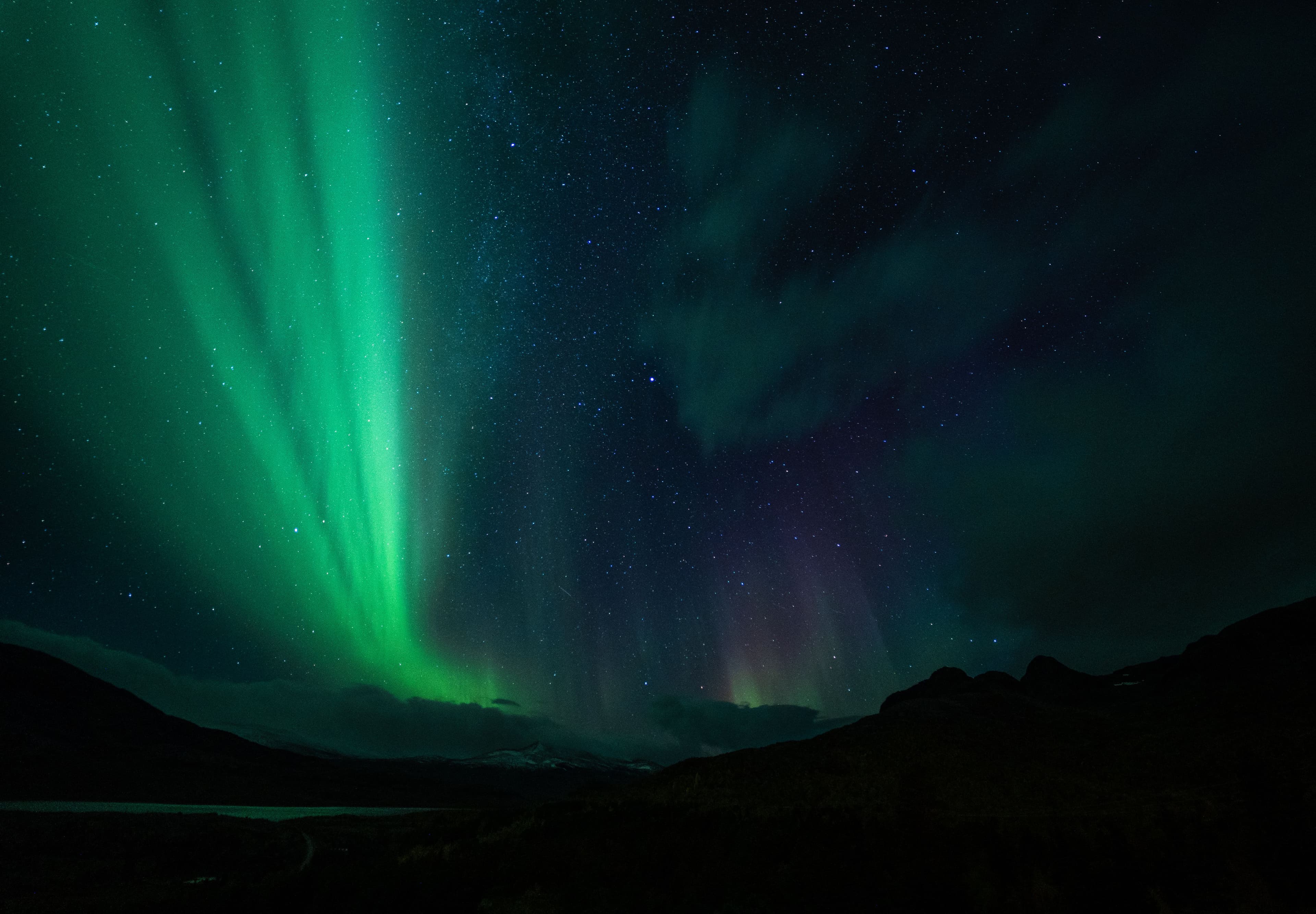 Green aurora borealis across a dark night sky